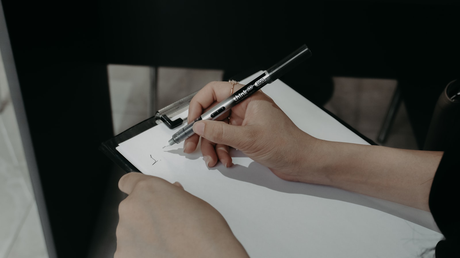 Händer skriver på papper med penna — illustrerar dokumentation